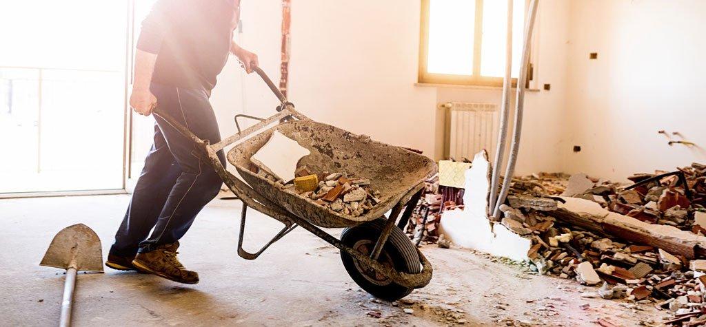 Home insurance home build man pushing wheel barrel