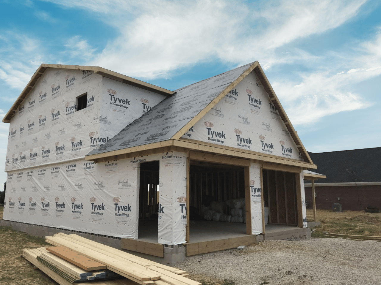 unfinished home being built with typar wrap wrapped around it
