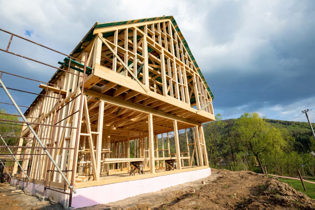 Construction delays concept with the frame of a wooden house under construction