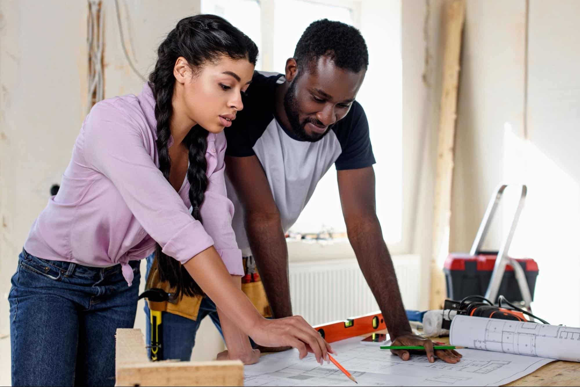 A couple looking at home blueprints for their new construction home