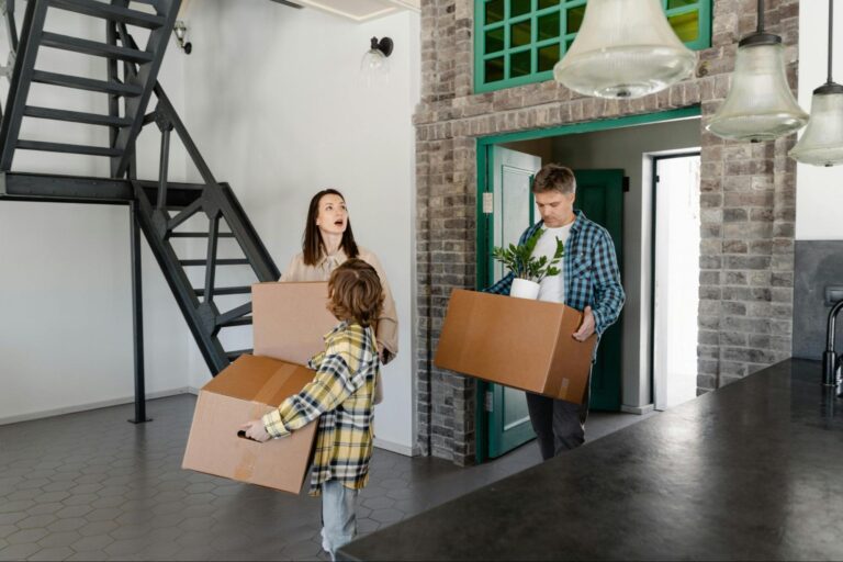 Family moving into a new home, carrying boxes and plants for fresh beginnings.