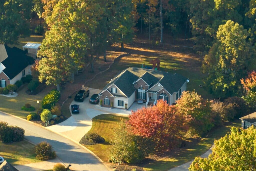 Aerial view of a lovely suburban home surrounded by vibrant autumn foliage.