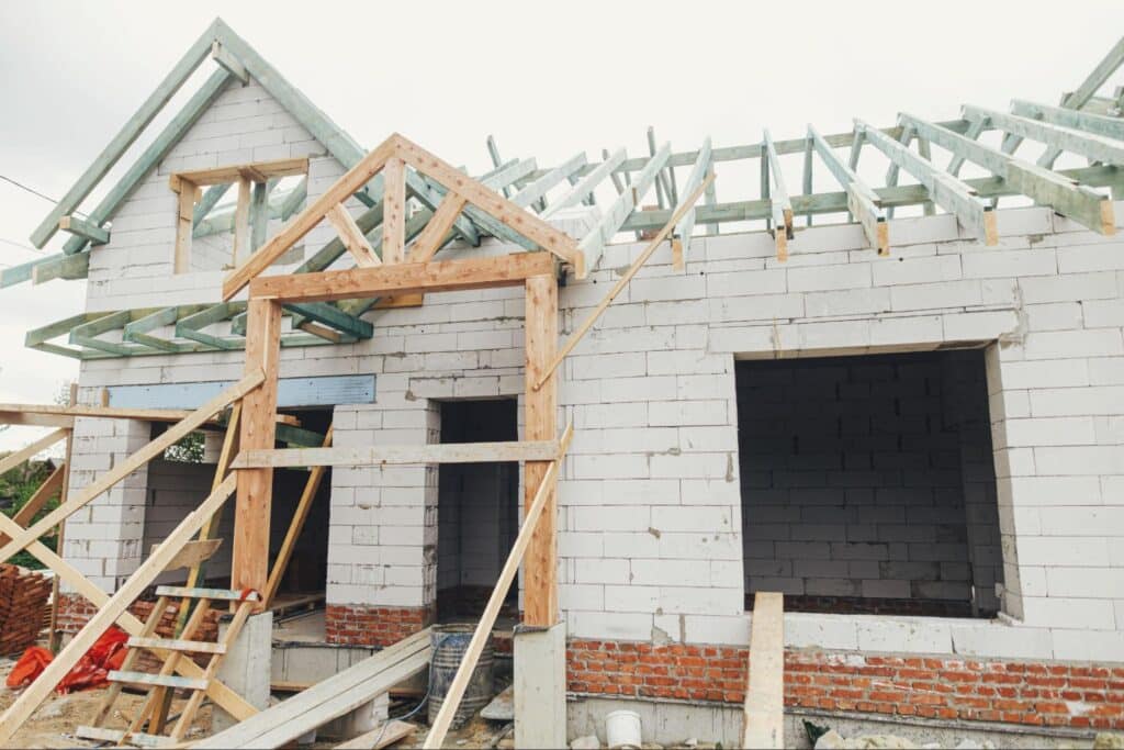 New home construction showing framed structure and roofing in progress.