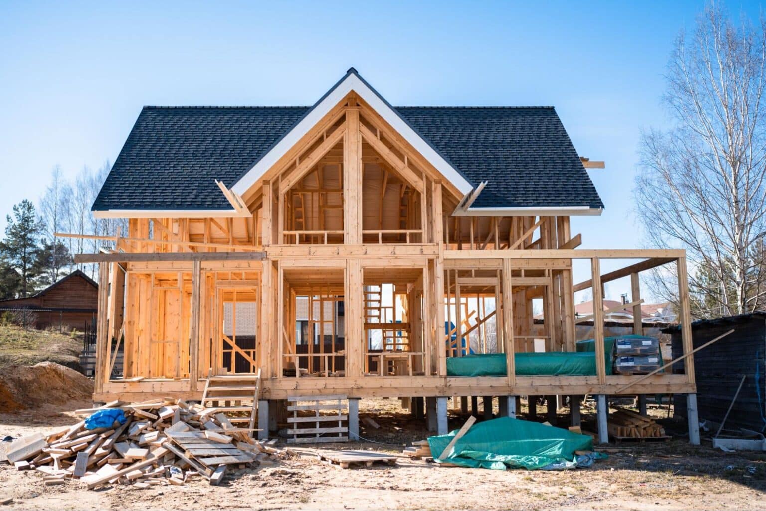 Newly built home under construction with wooden framing and a clear blue sky.