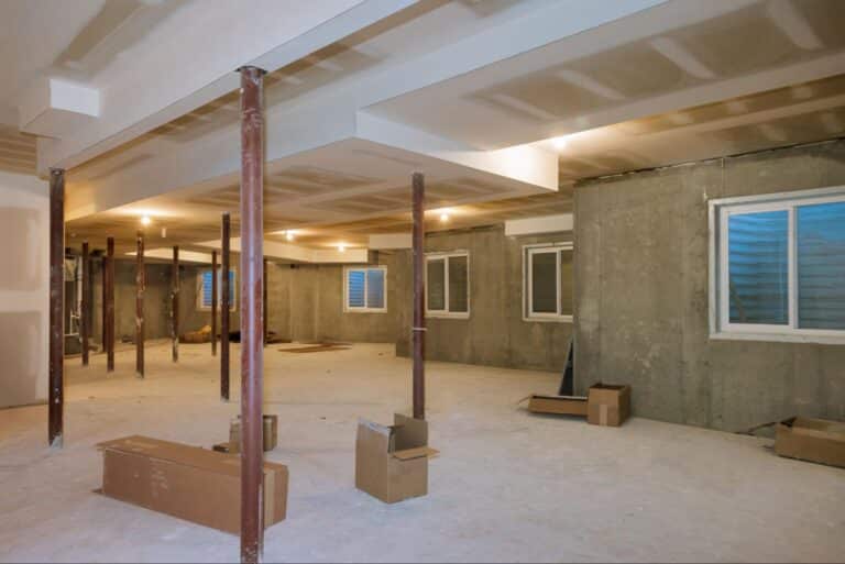 Basement renovation project showcasing open space and structural supports under construction.