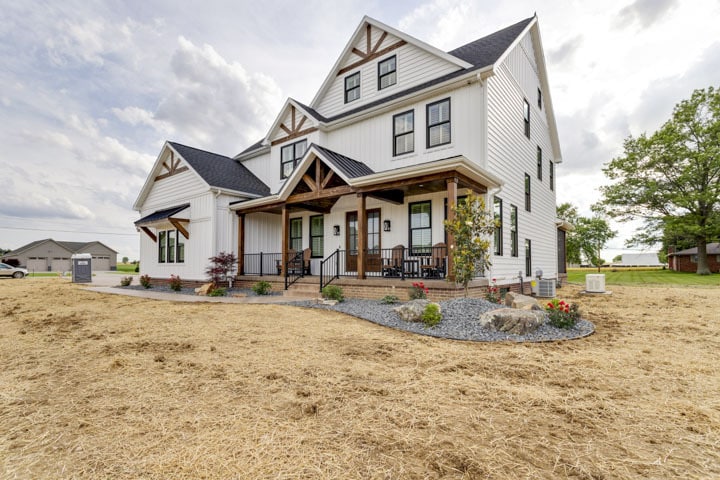Charming new home showcasing rustic design and a welcoming porch.