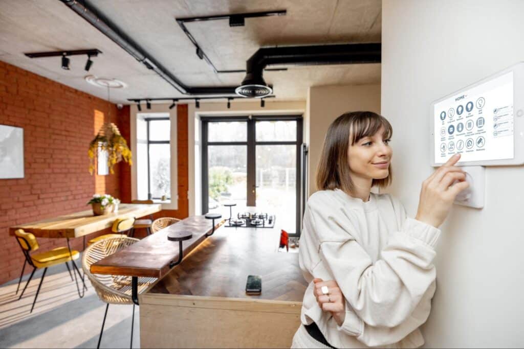 Woman adjusting the thermoostadt in a two-story home