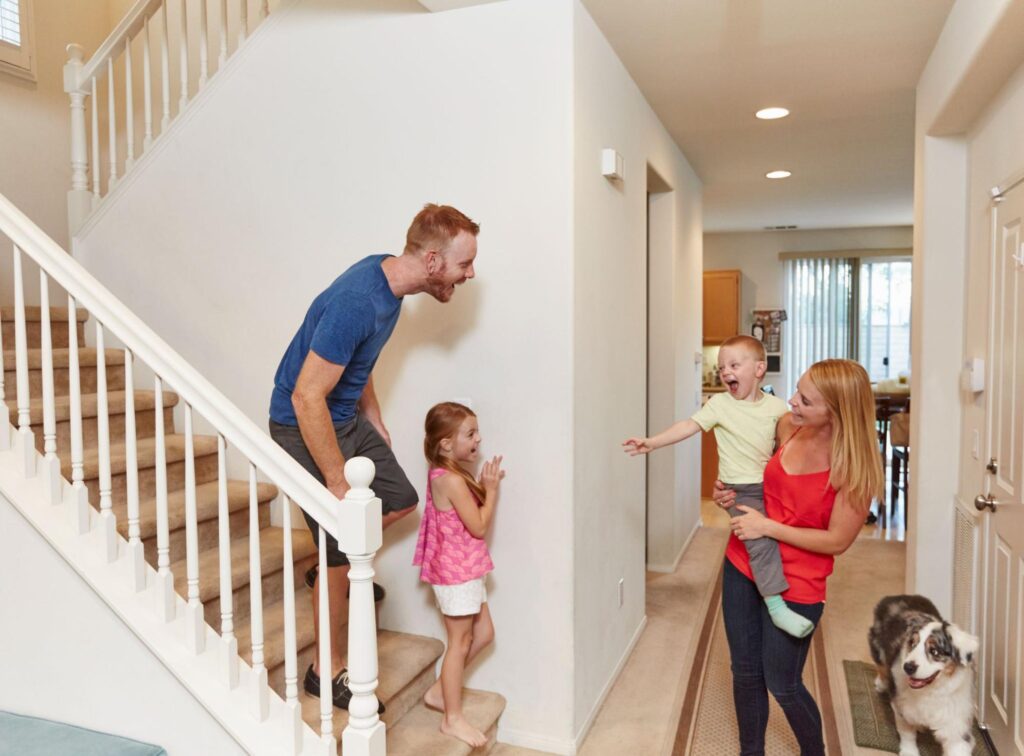 Family meeting at the stairs of a two-story home