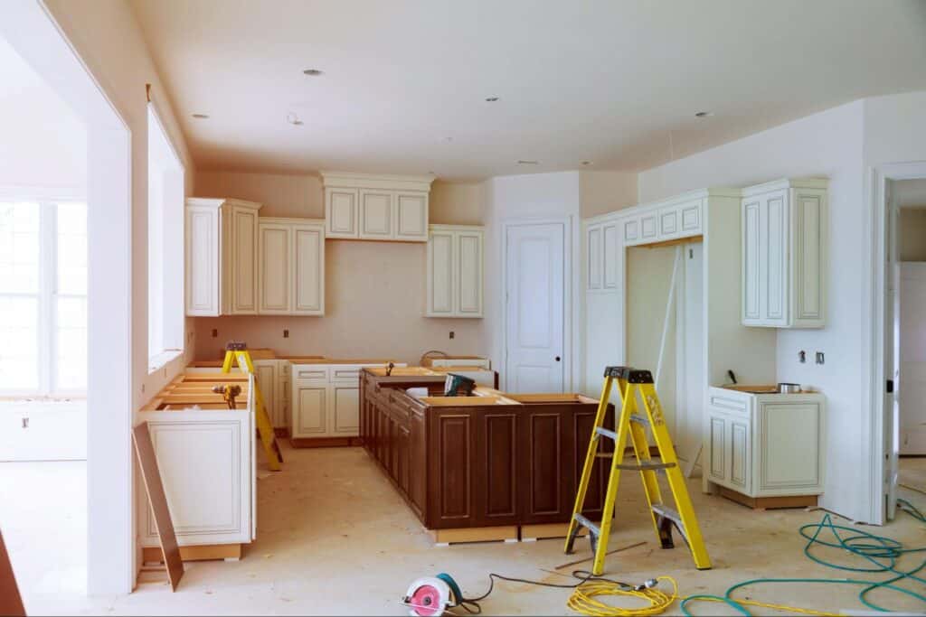 Modern kitchen renovation featuring cabinets and construction tools in progress.