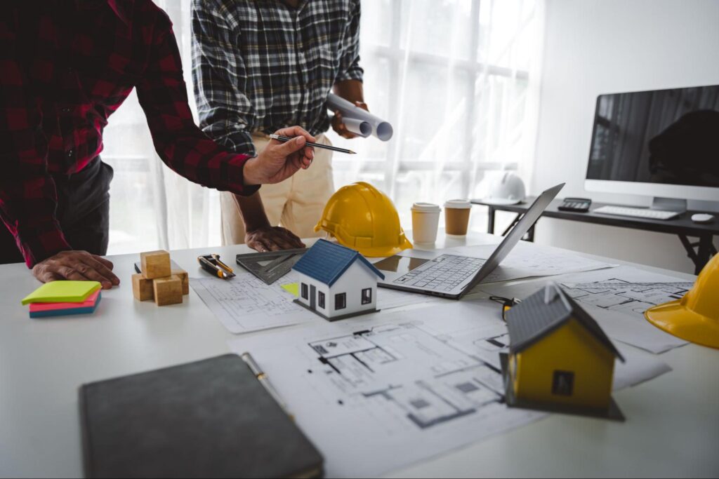 Property insurance concept with blueprints and house plans being discussed