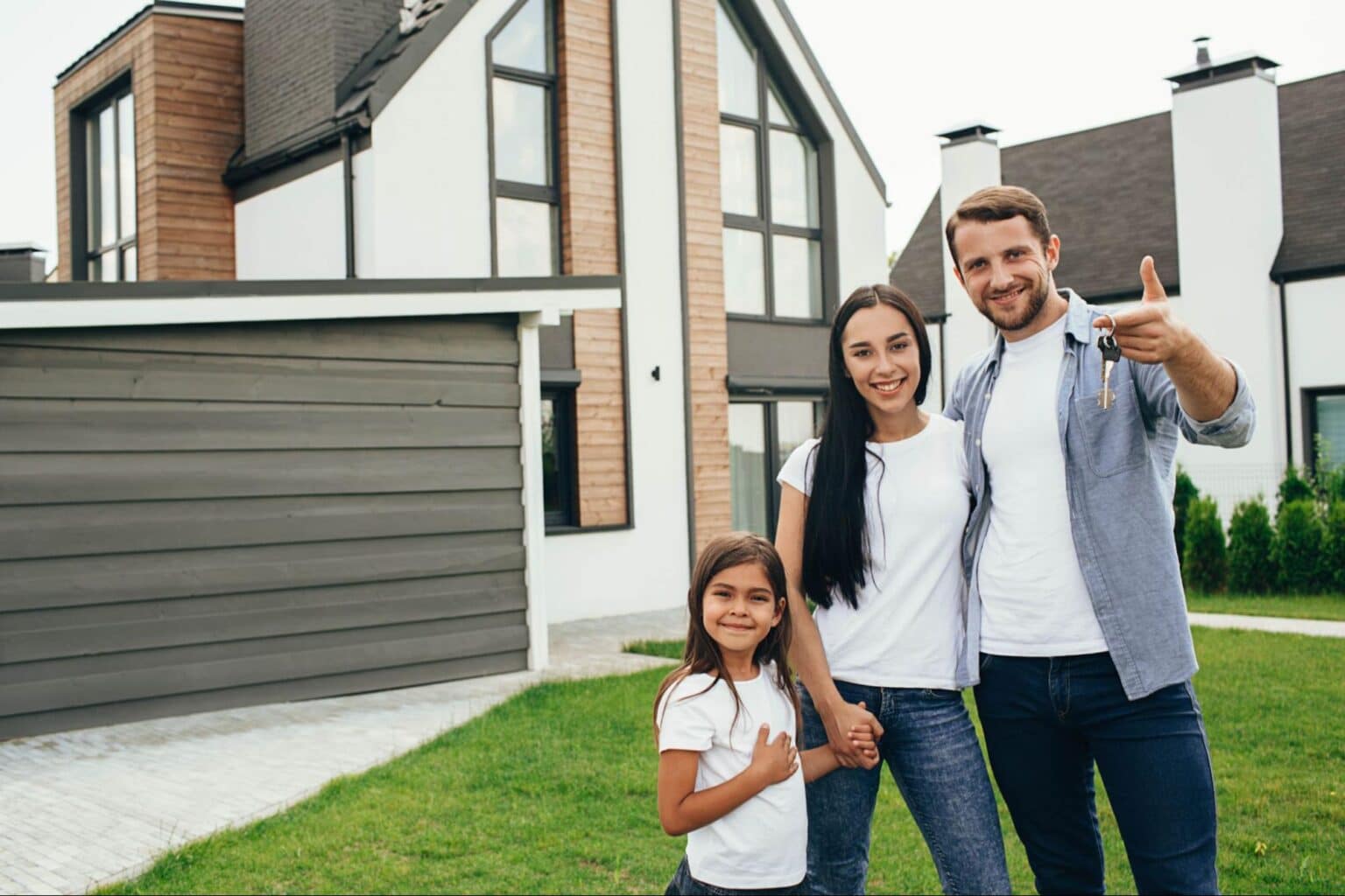Happy family standing in front of a modern home, enjoying their new neighborhood.