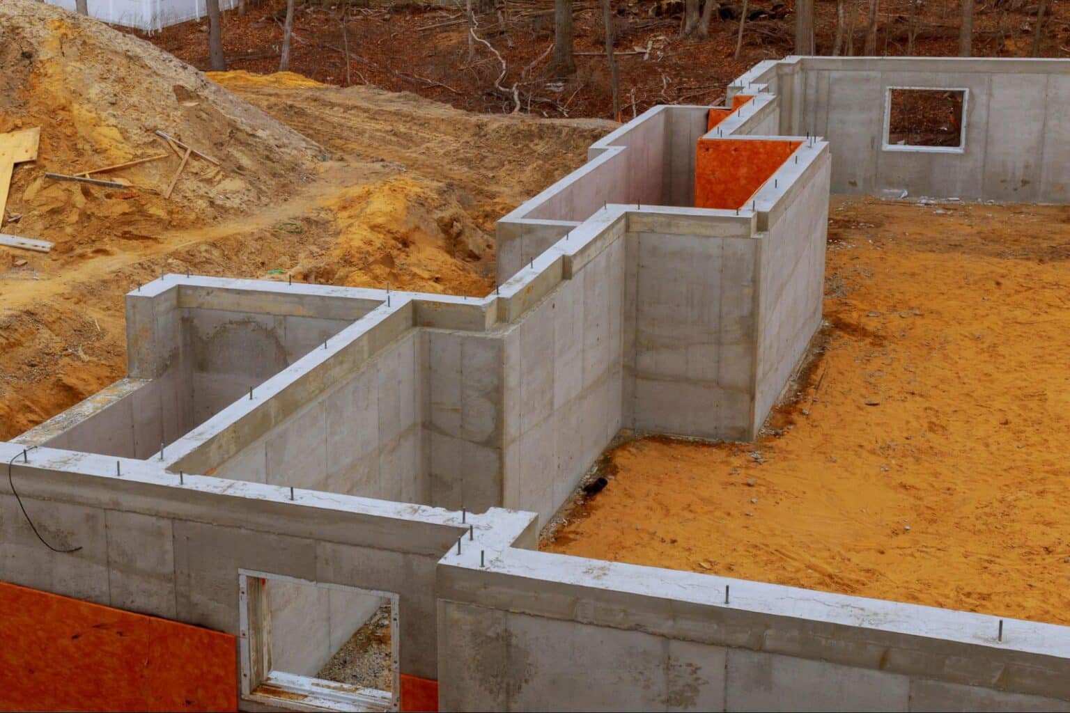 Construction site featuring a concrete foundation and walls in a residential building project.