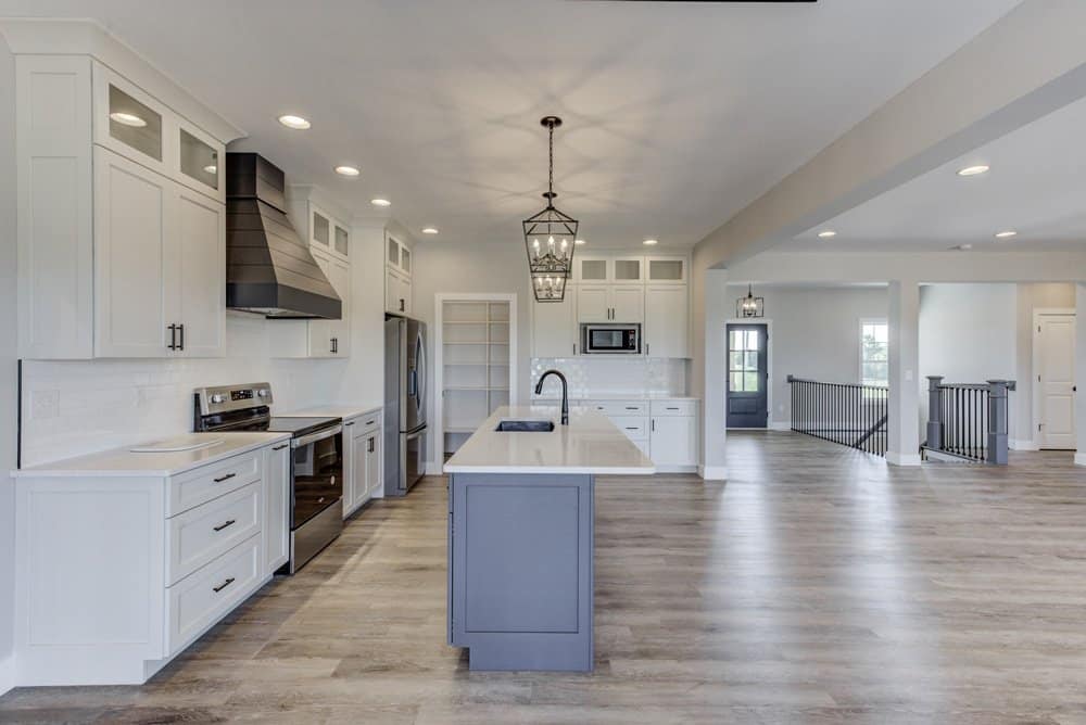 Bright, modern kitchen with white cabinets and spacious layout, conveying the build vs. buy a home concept