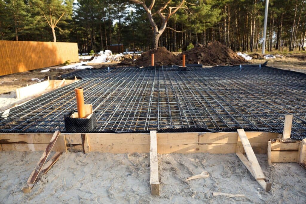Foundation groundwork ready for upcoming construction in a wooded area.
