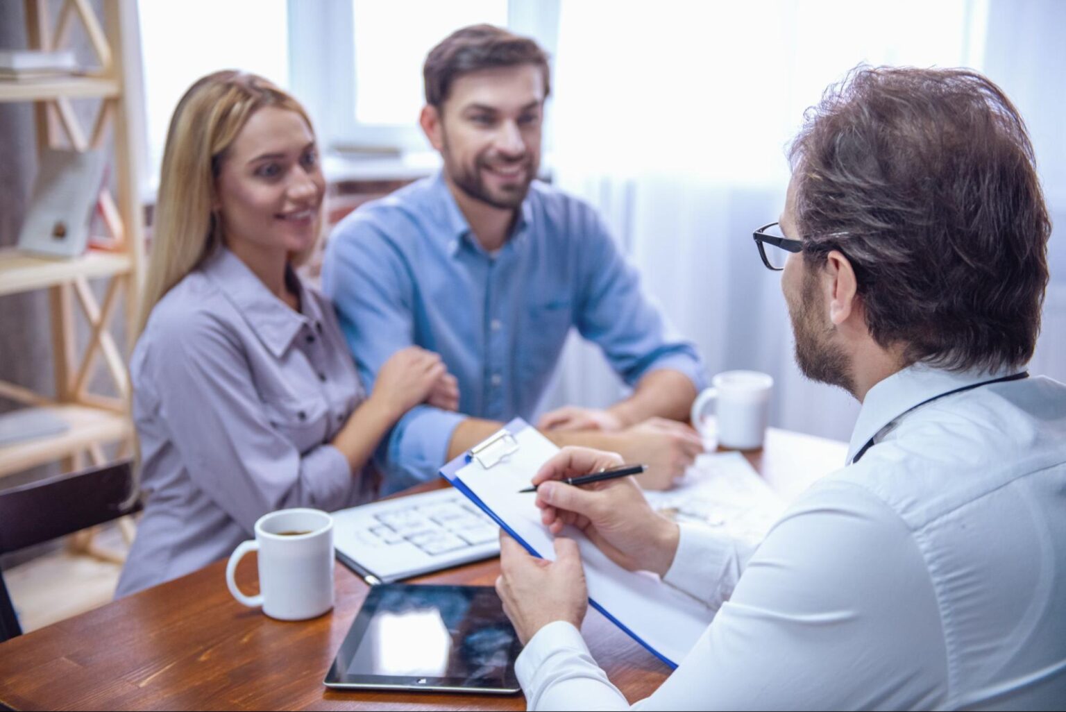 Couple consulting with an advisor about future plans at a meeting table.