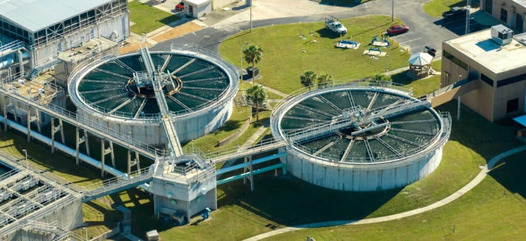 Aerial view of a modern wastewater treatment facility with circular tanks.