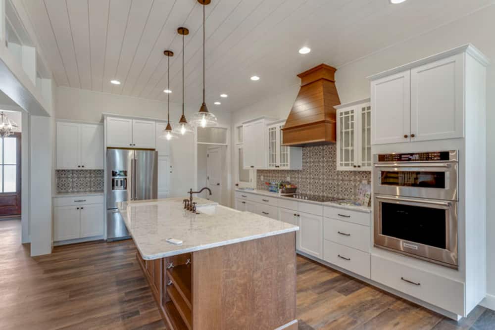 Stylish modern kitchen featuring white cabinets and warm wood details.