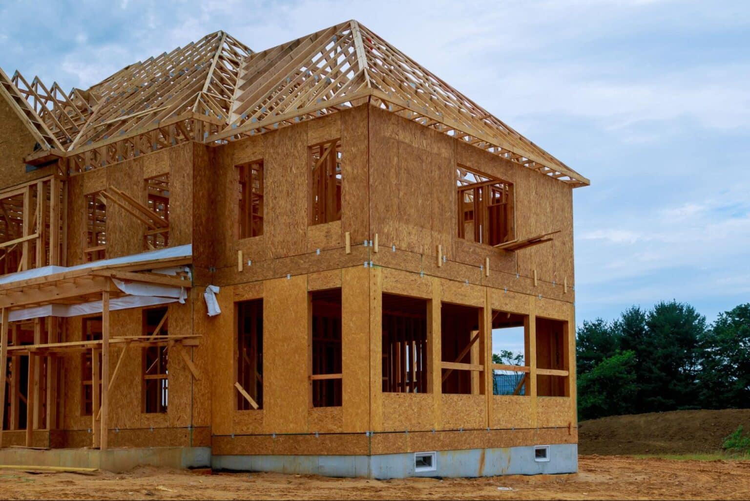 New wooden home under construction with exposed framing and trusses.