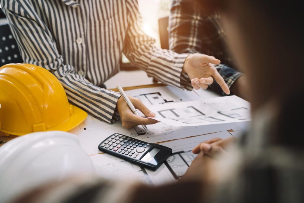 Construction professionals collaborating on project plans with tools and blueprints.