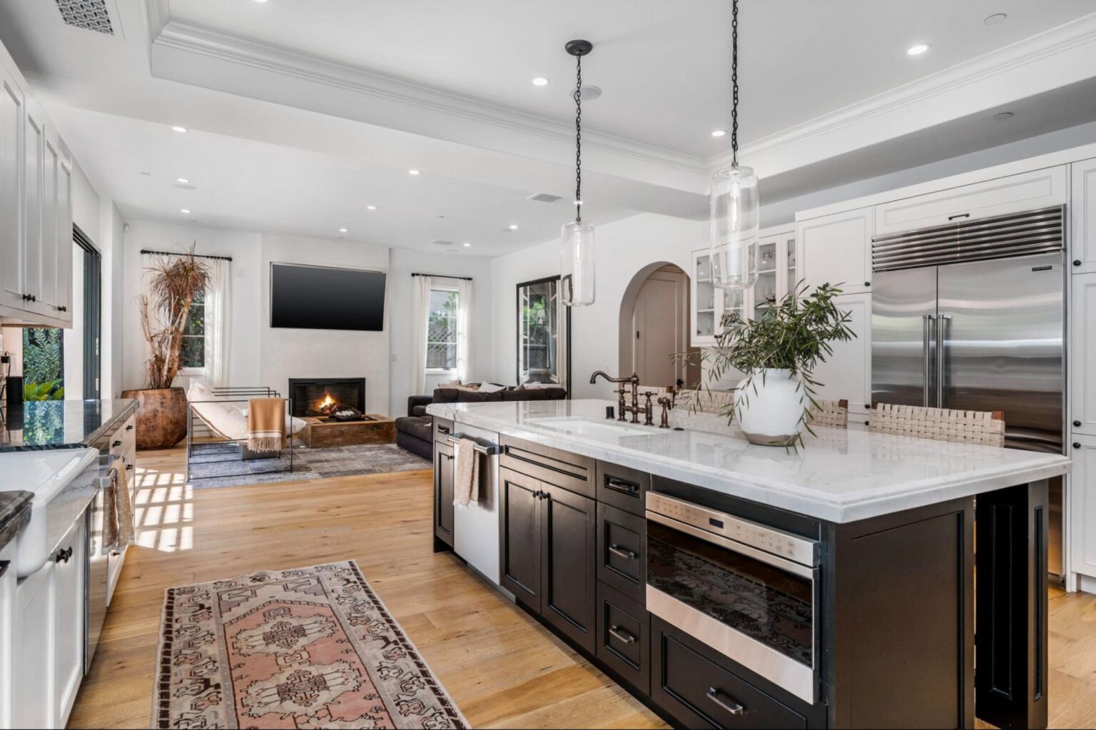 Stylish kitchen with large island and cozy living area, perfect for gatherings.