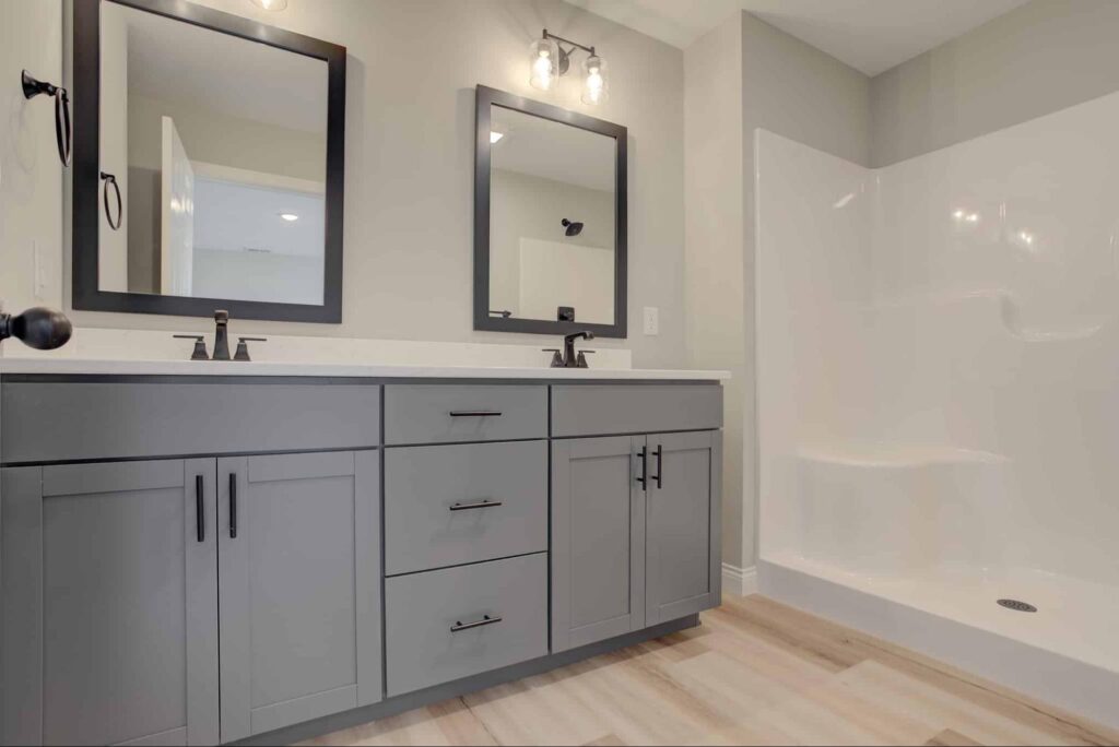 Stylish dual vanity bathroom with modern sinks and a sleek shower area.