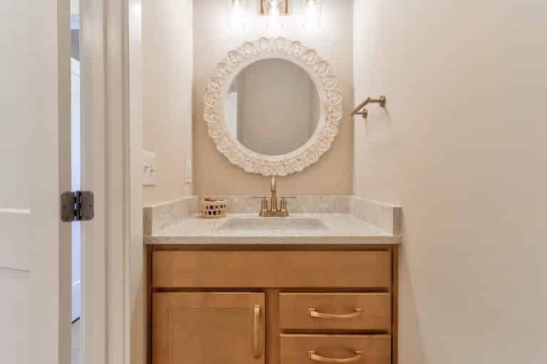 Elegant bathroom vanity with round mirror and stylish countertop in a modern setting.
