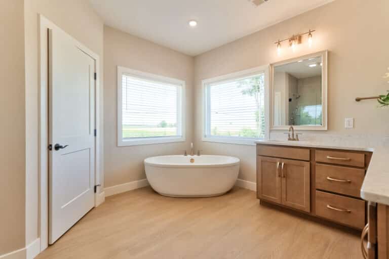 Bright and airy modern bathroom featuring a freestanding tub and wooden cabinetry.