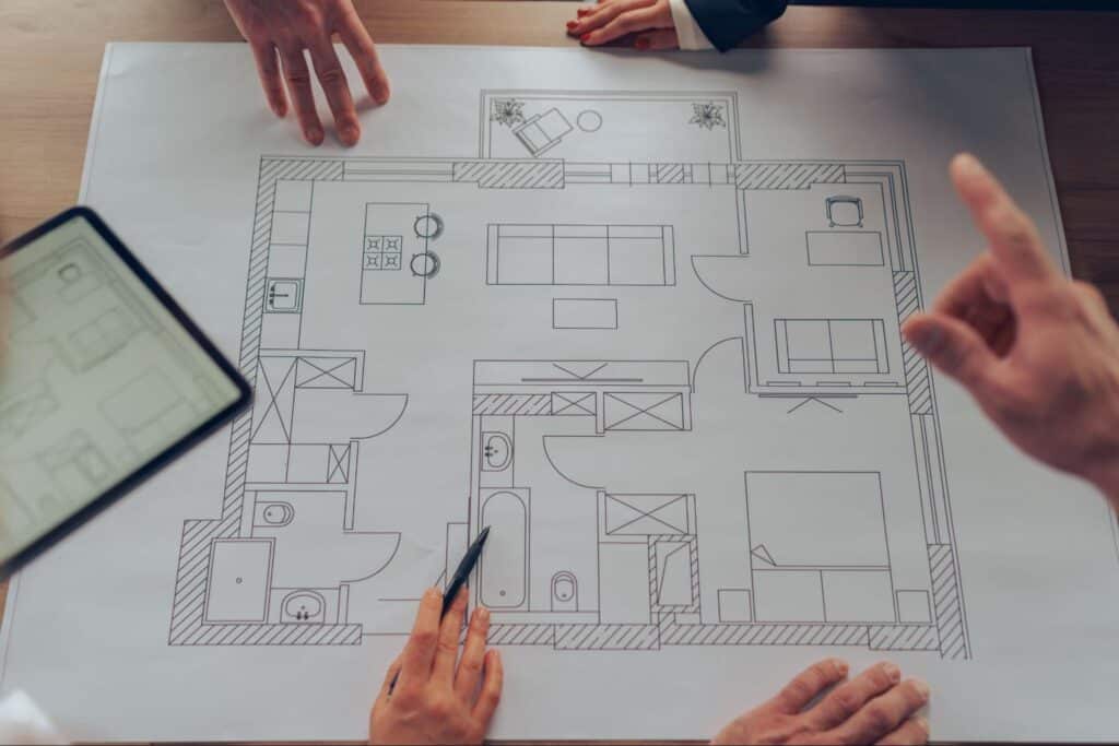 Team collaborating on a modern home design layout and floor plan.