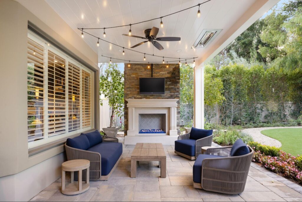 Chic outdoor lounge with a cozy fireplace and string lights for relaxing evenings.