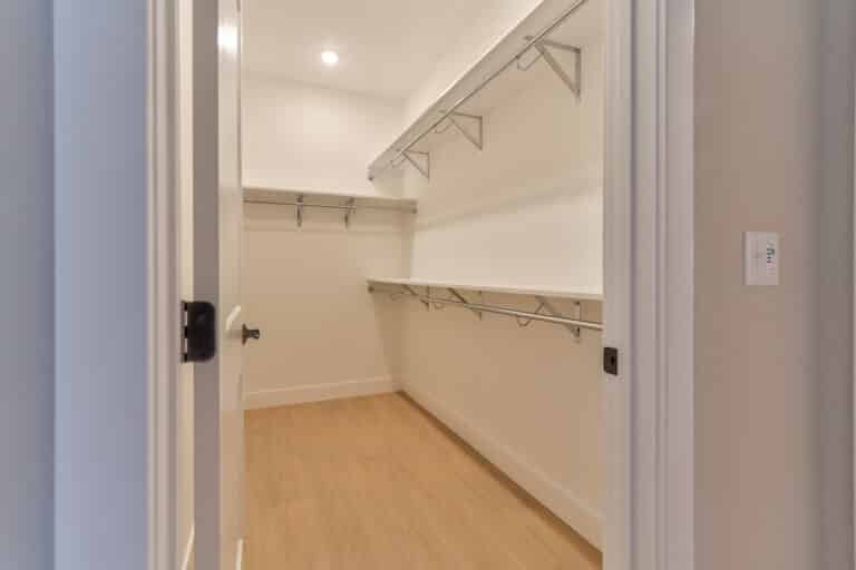 Spacious empty closet with shelving and hanging rods, ideal for organization.