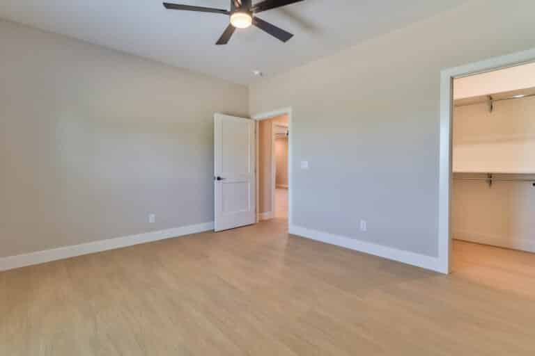 Spacious empty room interior with neutral walls and clean wooden flooring.
