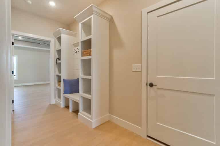 Stylish entryway storage with built-in shelves and seating for organization and aesthetics.