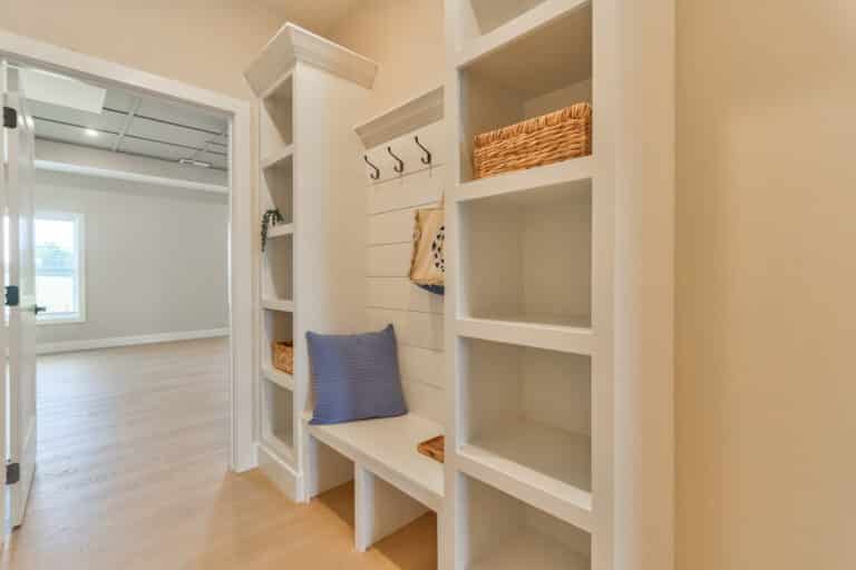 Stylish entryway storage shelves with hooks and baskets for organized space.