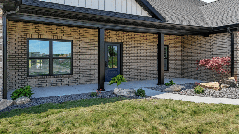 Charming summer house entrance with landscaped garden and modern brick facade.