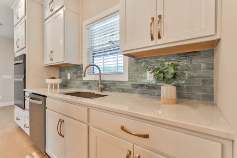Modern kitchen cabinets with a stylish sink and elegant backsplash design.