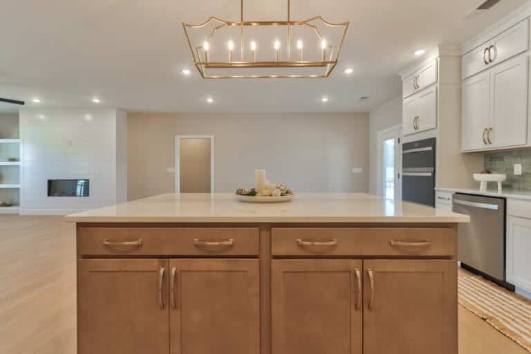 Modern kitchen island with elegant gold lighting and a minimalist design.