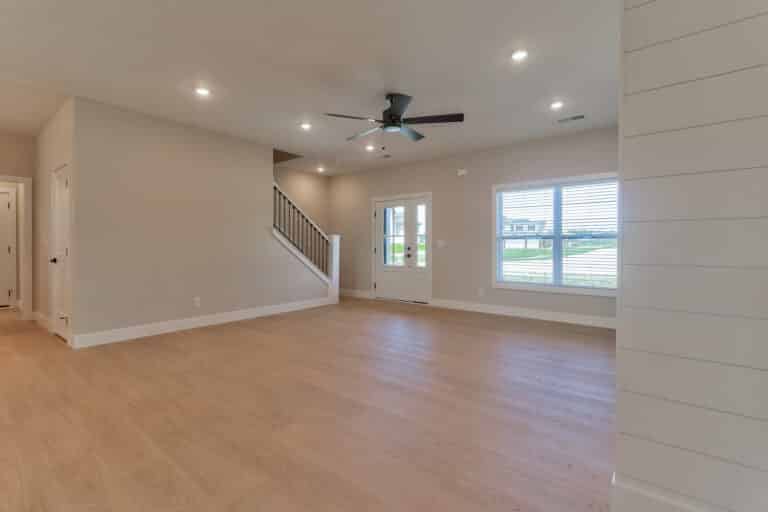 Spacious living room with modern design, natural light, and stylish staircase features.