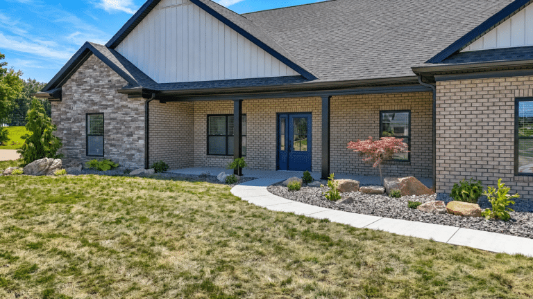 Modern home entryway with landscaped garden and stylish blue door.