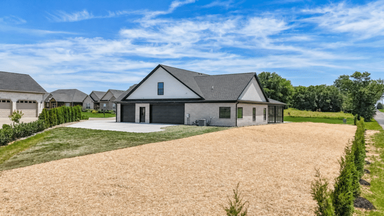 Stylish modern home with landscaped yard and clear blue sky.