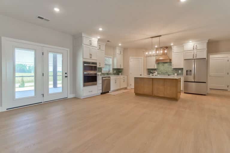 Spacious modern kitchen featuring elegant cabinetry and stylish light fixtures.