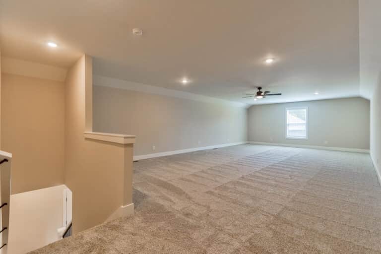 Spacious living room with plush carpet and abundant natural light for comfort.