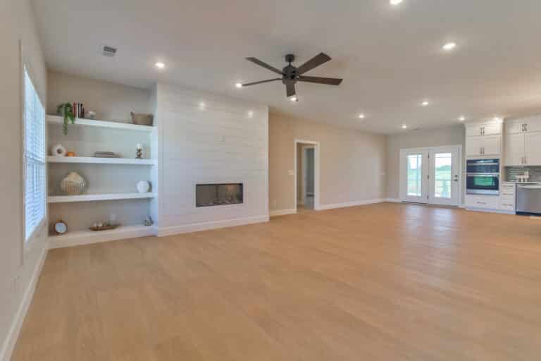Modern spacious living room with natural light, open design, and stylish fireplace.