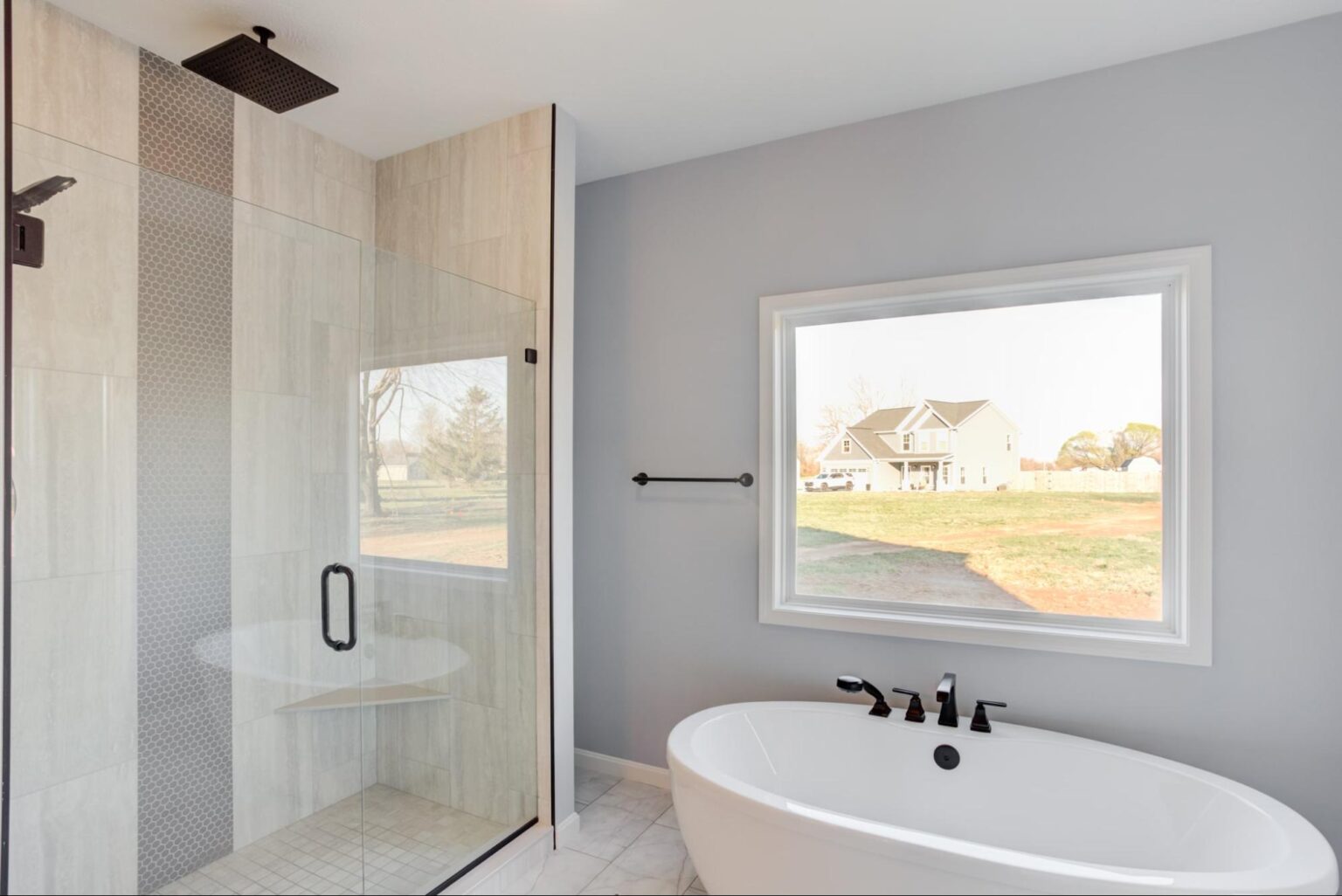 Chic modern bathroom featuring a shower, freestanding tub, and ample natural light.