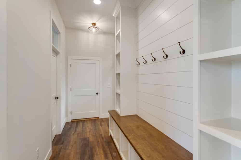 Chic mudroom featuring a wood bench and stylish hooks for efficient organization.