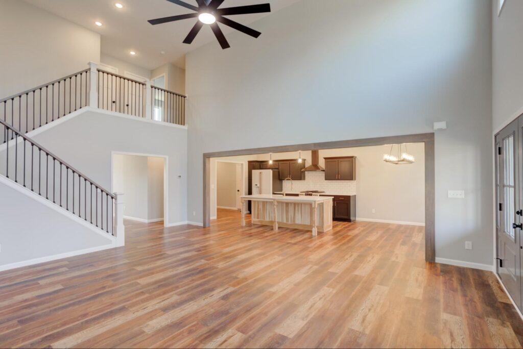 Stylish open-concept living room and kitchen with hardwood flooring and modern design.
