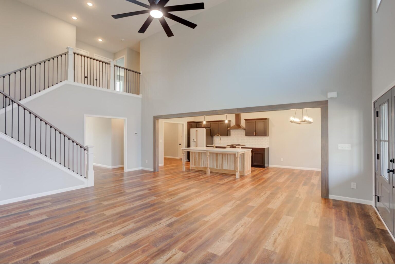Stylish open-concept living room and kitchen with hardwood flooring and modern design.