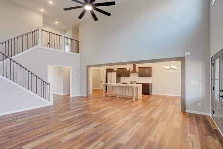 Stylish open-concept living room and kitchen with hardwood flooring and modern design.