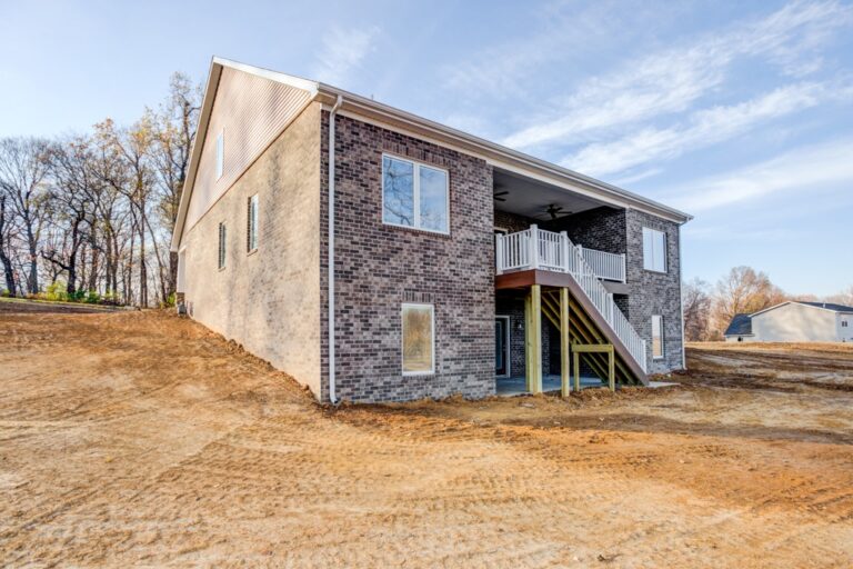 Modern brick home with a spacious outdoor deck and serene surroundings.