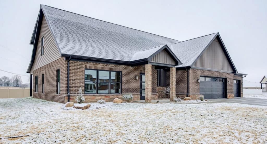 Charming brick home surrounded by a serene snowy landscape, ideal for winter aesthetics.