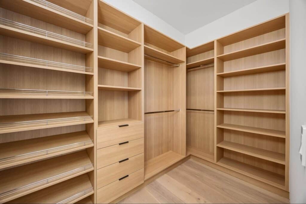 Elegant walk-in closet featuring smart, organized storage options and wooden finishes.